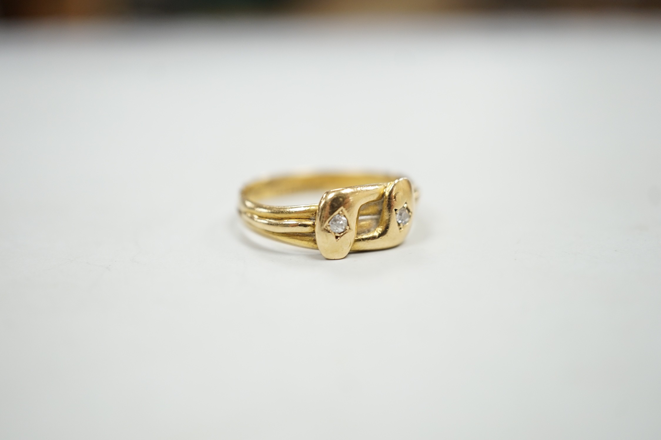 A late Victorian 18ct gold and two stone diamond set twin serpent ring, size L, gross weight 2.6 grams.